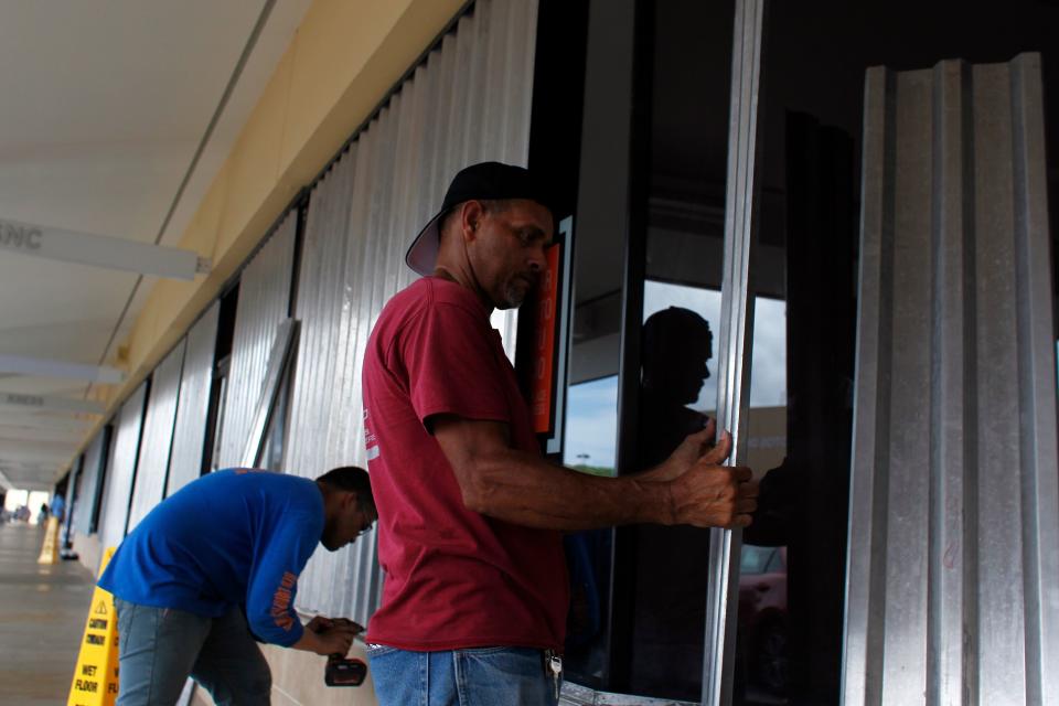 Workers install storm shutters as hurricane Irma approaches Puerto Rico in Fajardo.