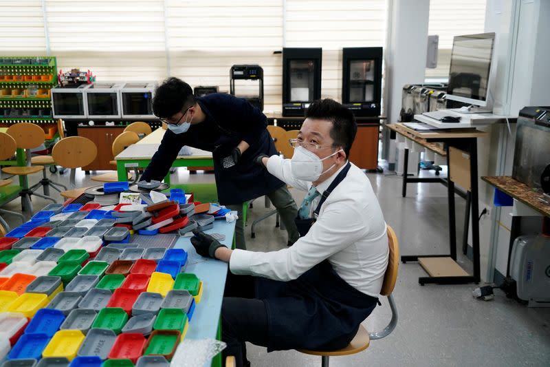 A professor of Pusan National University Park Hyun who used to be a coronavirus patient, talks with his colleagues as he works at Pusan National University in Busan