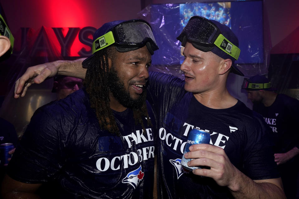 Toronto Blue Jays' Vladimir Guerrero Jr., left, celebrates with teammates in the locker room after clinching a berth in the AL wild card series following a baseball game against the Tampa Bay Rays in Toronto, Sunday, Oct. 1, 2023. (Frank Gunn/The Canadian Press via AP)