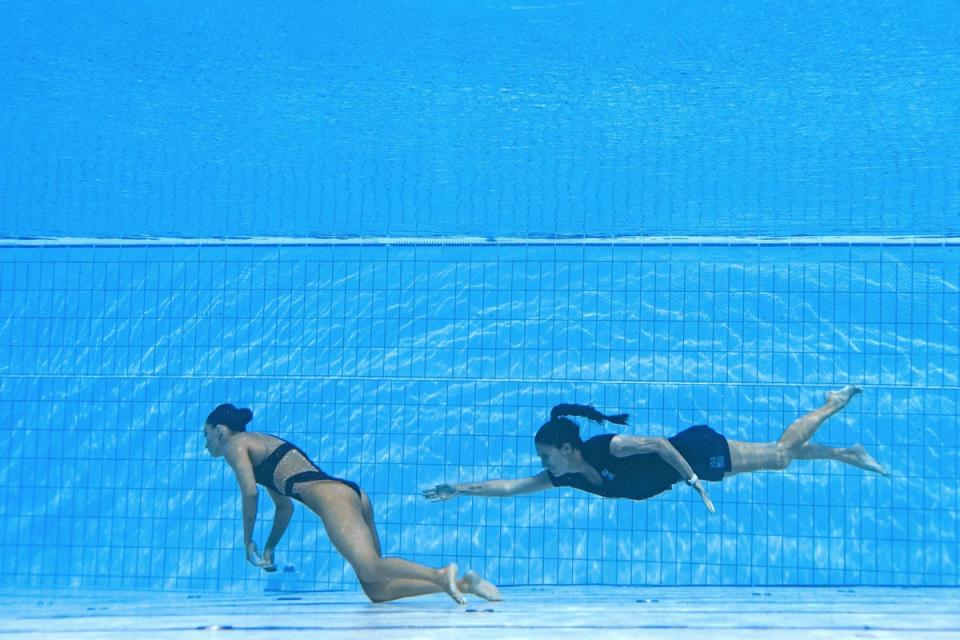 USA coach Andrea Fuentes, right, swims to recover Anita Alvarez, from the bottom of the pool after the athlete fainted whilst performing in the women’s solo free artistic swimming finals, at the Budapest World Aquatics Championships (AFP/Getty)