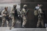 Members of the Security Service of Ukraine (SBU) enter a building where an unidentified man reportedly threatens to blow up a bomb in a bank branch, in Kyiv