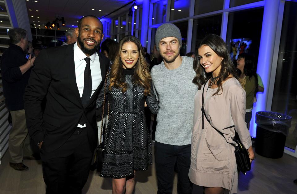 Two men and two women pose and smile at an event.