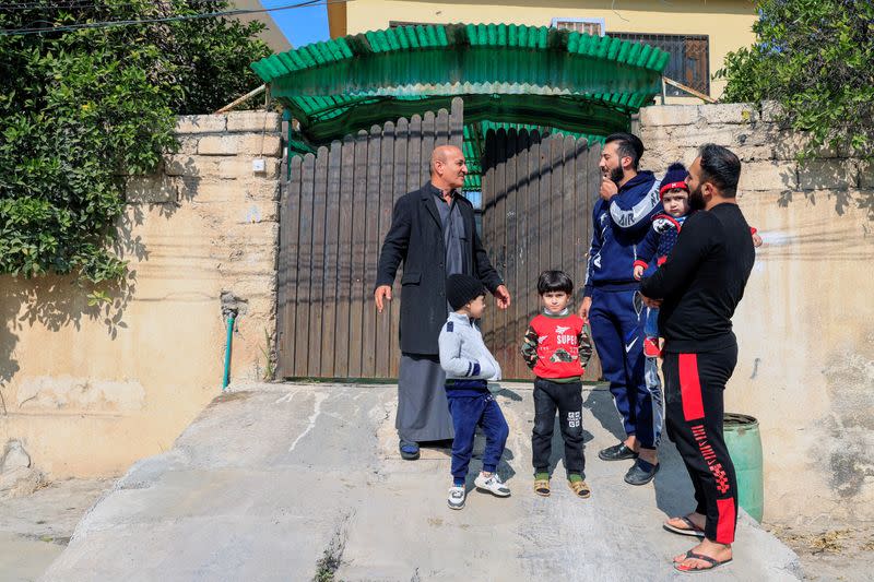 Thanoun Yahya, an Iraqi Christian talks with his Muslim neighbors near his home which he reclaimed when Islamic State militants was driven out, in Mosul