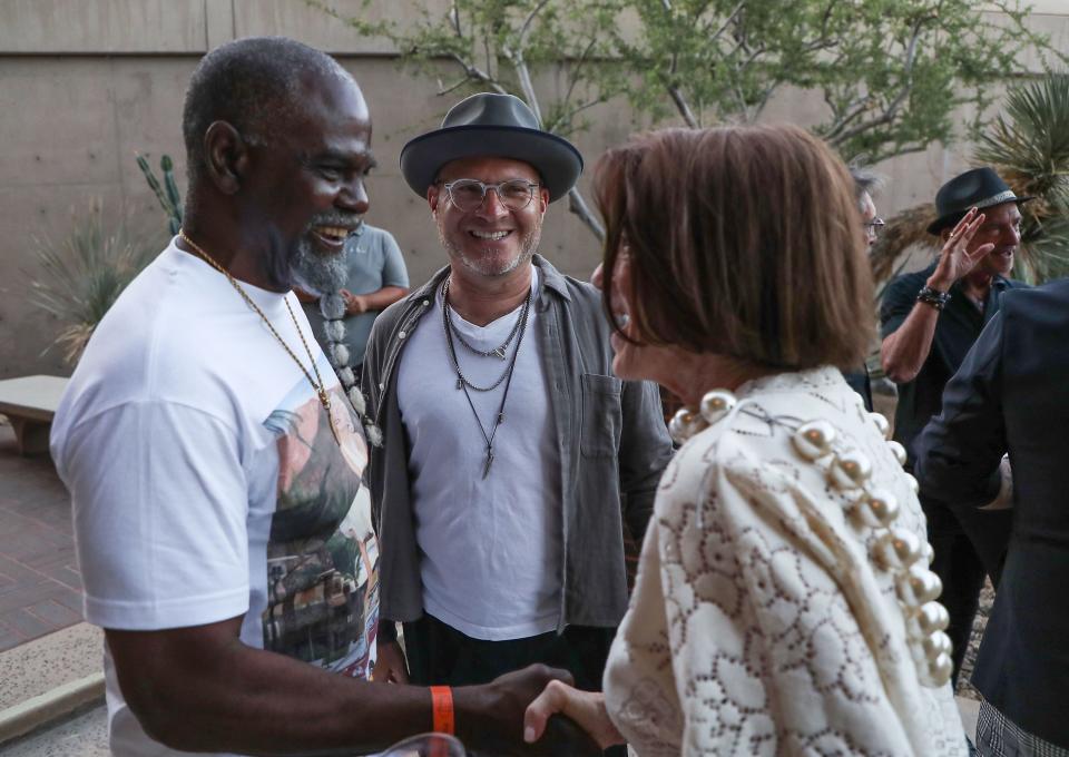 Artist Mr. Wash, left, meets Dia Weil, right, as Executive Director Adam Lerner, center, looks on during the debut of new exhibits by Wash and others at the Palm Springs Art Musuem in Palm Springs, Calif., April 21, 2022.