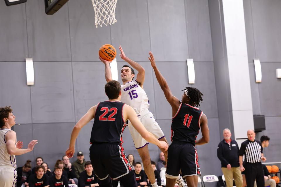 Poughkeepsie native Hayden Peek, playing for New York University, drives the lane and readies to shoot during a 2023 men's basketball game.
