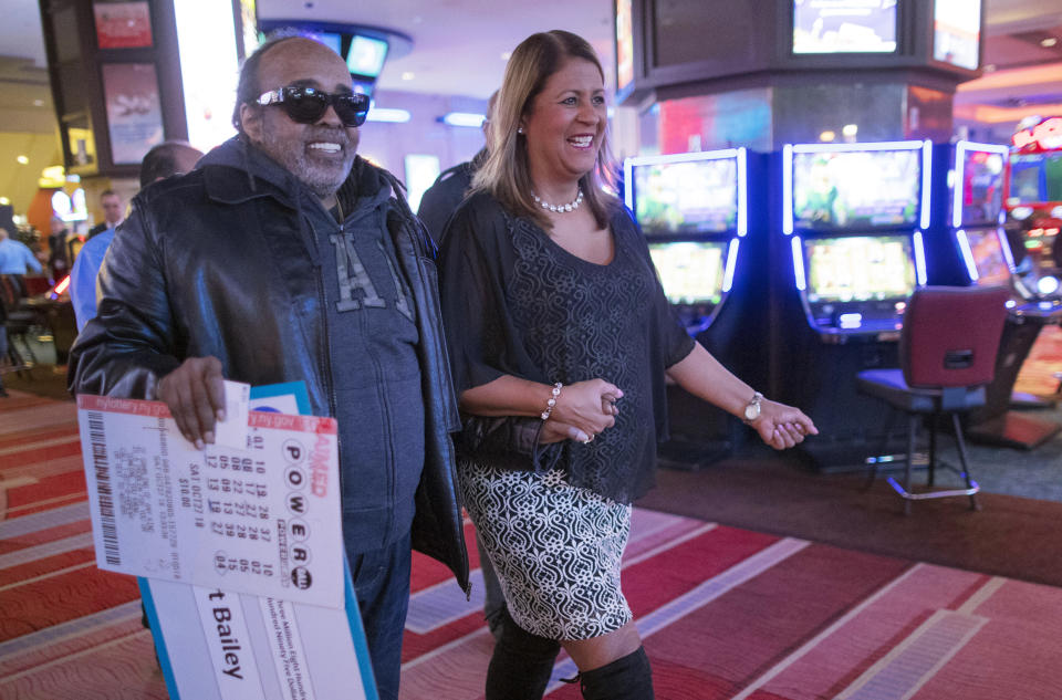 Robert Bailey, left, is joined by New York Lottery's Yolanda Vega as they walk away from a news conference at the Resorts World Casino New York City, Wednesday, Nov. 14, 2018, in New York. The retired government worker won over $343 million in Powerball, the biggest jackpot in New York state lottery history. (AP Photo/Mary Altaffer)