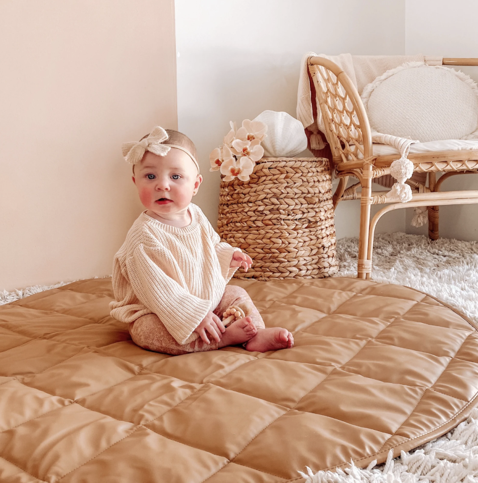 Baby sitting on play mat