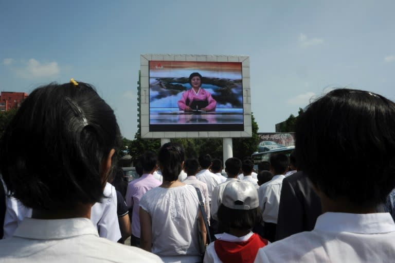 Pyongyang residents watch TV announcer Ri Chun-Hee speak about the successful launch of the intercontinental ballistic missile "Hwasong-14" on a big screen near the Pyongyang Railway Station in Pyongyang on July 4, 2017