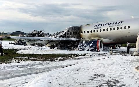 The Sukhoi Superjet 100 aircraft of Aeroflot Airlines is covered in fire retardant foam after an emergency landing in Sheremetyevo airport in Moscow - Credit: AP