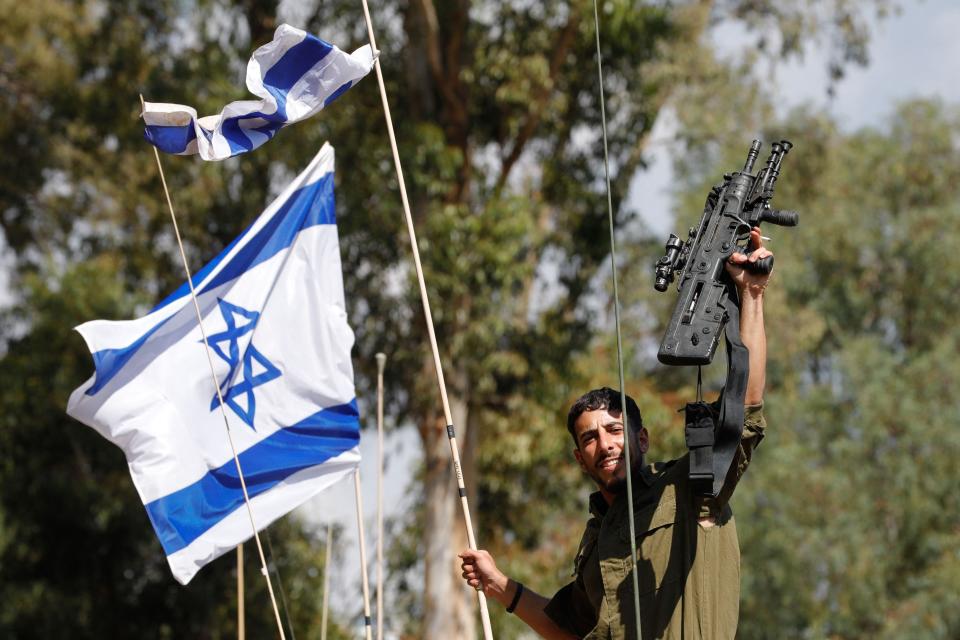 An Israeli soldier gestures as he rides on a military vehicle in the northern town of Kiryat Shmona close to the border with Lebanon on Oct. 16, 2023. Israel's army said it was evacuating residents living along its northern border with Lebanon.