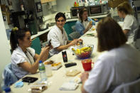 FILE - In this Wednesday, Dec. 16, 2020 file photo, Nurse Anne-Catherine Charlier, center, talks to colleagues during a dinner break in the intensive care ward for COVID-19 patients at the CHR Citadelle hospital in Liege, Belgium. The European Union executive announced Thursday, March 4, 2021 that it wants to force employers to be much more open about how much money staff makes to make it easier for women to challenge wage imbalances and further closer the gender pay gap. The EU made it clear that women workers had been disproportionally affected by the pandemic, many having to add more home tasks to their work schedule because of closure of schools and day care centers. (AP Photo/Francisco Seco, File)