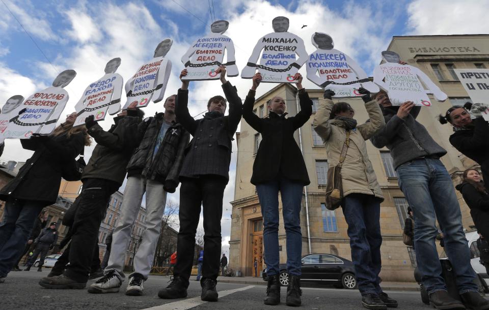 Demonstrators hold cutouts of arrested opposition activists with their photos and names during a 'March against Hatred' in St. Petersburg, Russia, Saturday, Oct. 27, 2012. Russians are protesting against a ongoing crackdown on the opposition which was launched his spring, with arrests of activists and introduction of new harsh legislation. (AP Photo/Dmitry Lovetsky)