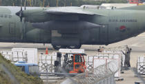 In this Nov. 11, 2018 photo, South Korean soldiers prepare to load boxes of tangerines near South Korea's Air Force cargo plane C-130 at the Jeju International Airport on Jeju Island, South Korea. South Korea has airlifted thousands of boxes of tangerines to North Korea in return for the North's large shipments of pine mushrooms in September.(Park Ji-ho/Yonhap via AP)