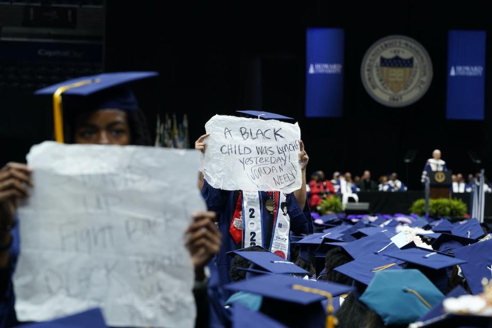 College graduates hold signs reading ‘A Black child was lynched yesterday! Jordan Neely’ and ‘Stand up, Fight Back, Black People Under Attack’ as U.S. President Joe Biden speaks at Howard University’s commencement in Washington, D.C., in May 2023. (AP Photo/Alex Brandon)