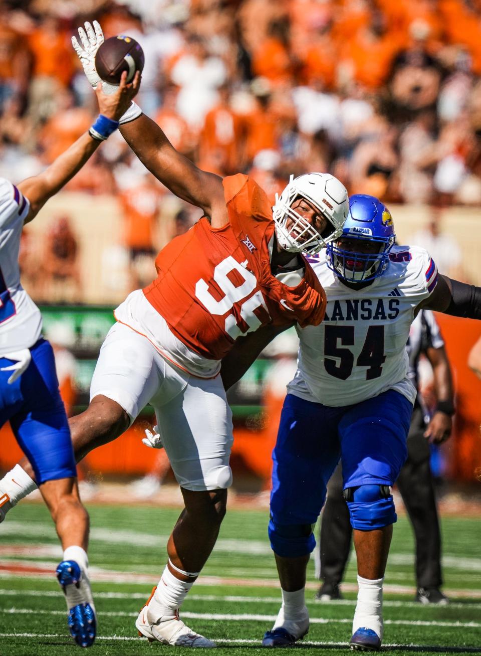 Texas defensive lineman Alfred Collins raises his arm to try to block a pass from Kansas quarterback Jason Bean in the second quarter of Saturday's game at Royal-Memorial Stadium. Bean got the surprise start in place of regular starter Jalon Daniels, who's having back issues.