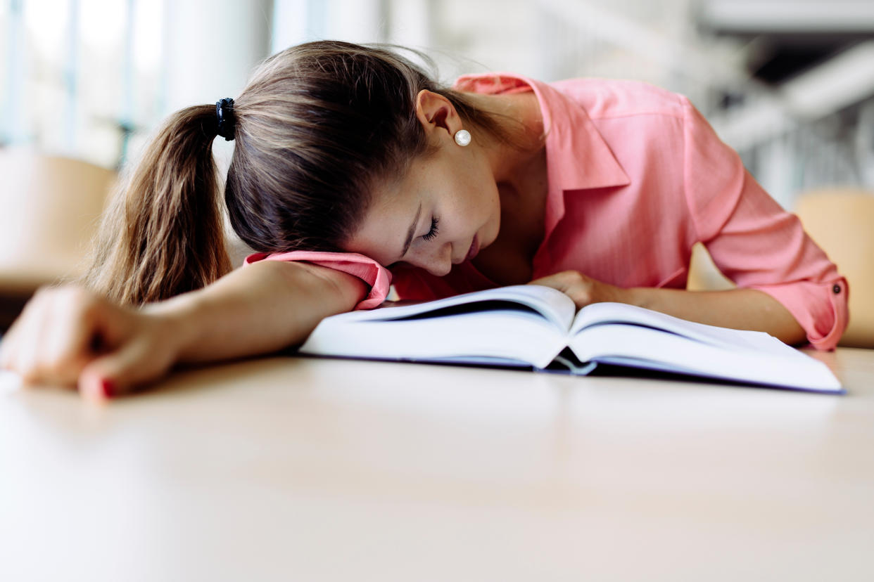 Girl sleeping over her book