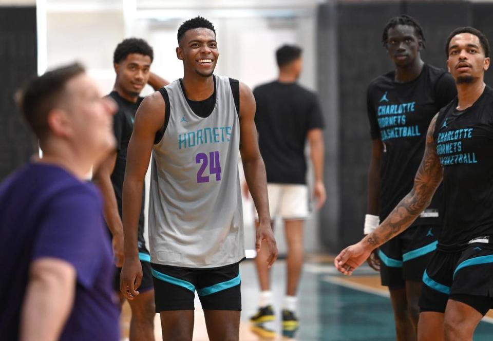 Charlotte Hornets rookie forward/guard Brandon Miller, center, smiles as he watches a shot by teammate P.J. Washington, right, during practice on Tuesday, October 3, 2023 at Spectrum Center in Charlotte, NC.
