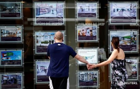 A couple view properties for sale in an estate agents window in London, Britain August 22, 2016. REUTERS/Peter Nicholls/File Photo