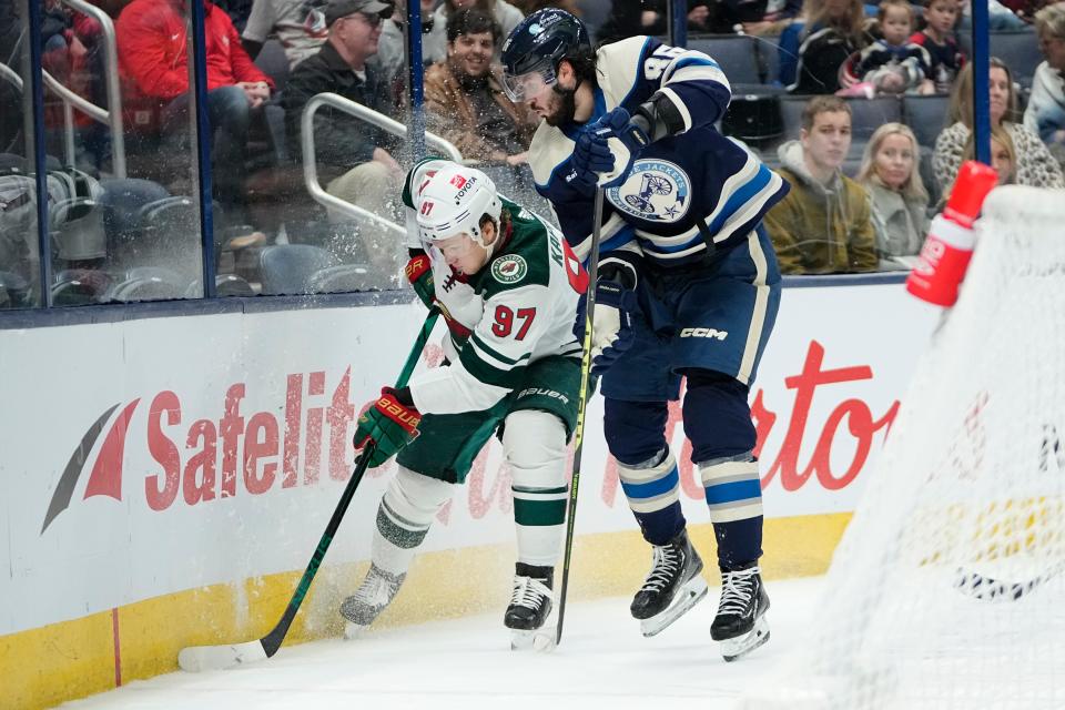 Feb 23, 2023; Columbus, Ohio, USA;  Columbus Blue Jackets right wing Kirill Marchenko (86) fights for a puck with Minnesota Wild left wing Kirill Kaprizov (97) during the third period of the NHL hockey game at Nationwide Arena. The Blue Jackets lost 2-0. Mandatory Credit: Adam Cairns-The Columbus Dispatch