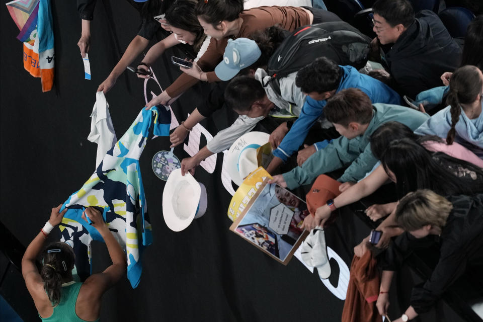Zheng Qinwen of China signs autographs after defeating Dayana Yastremska of Ukraine in semifinal match at the Australian Open tennis championships at Melbourne Park, Melbourne, Australia, Thursday, Jan. 25, 2024. (AP Photo/Louise Delmotte)