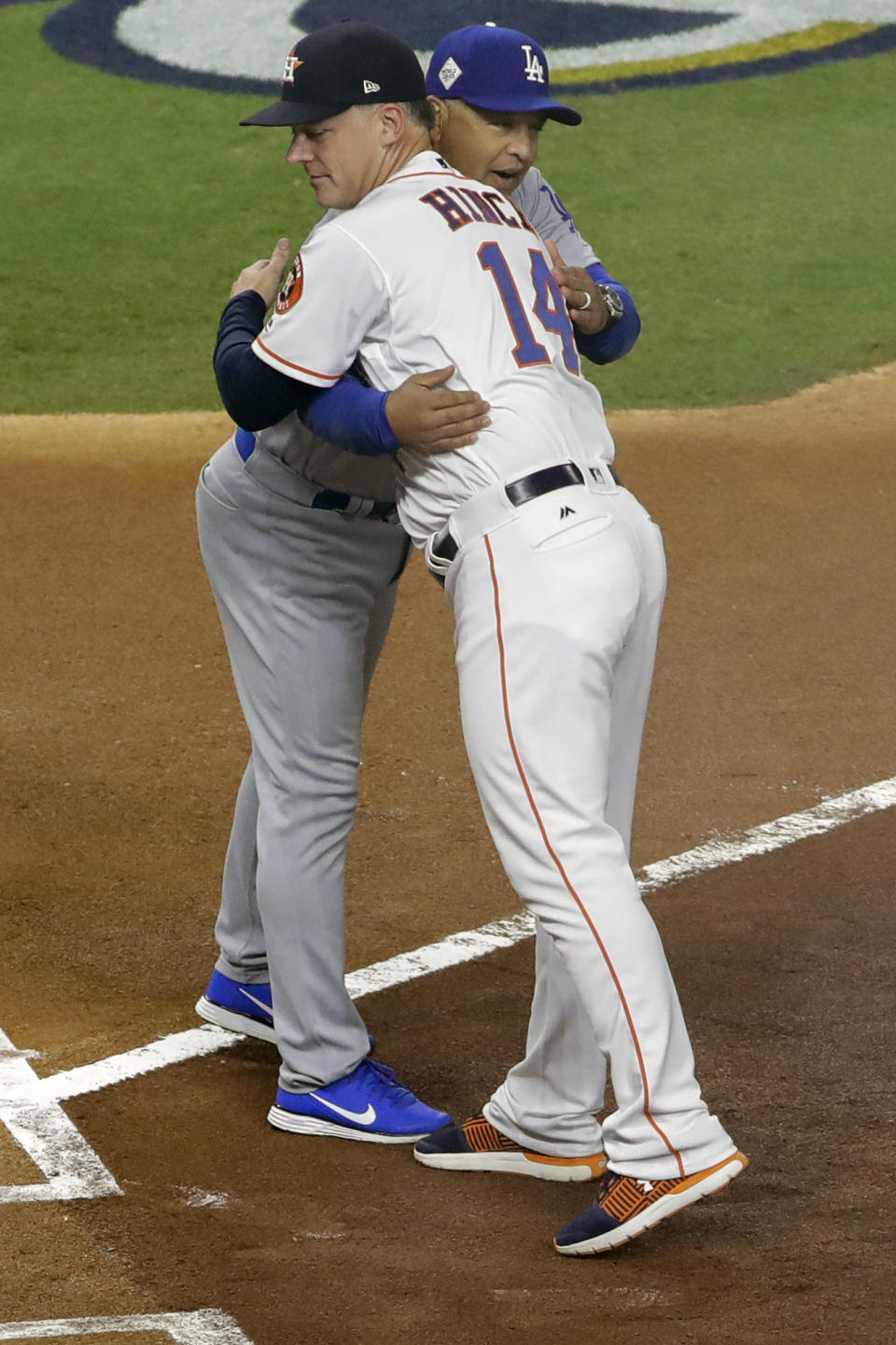 FILE - In this Oct. 27, 2017, file photo, Houston Astros manager A.J. Hinch hugs Los Angeles Dodgers manager Dave Roberts before Game 3 of baseball's World Series in Houston. Houston manager AJ Hinch and general manager Jeff Luhnow were suspended for the entire season Monday, Jan. 13, 2020, and the team was fined $5 million for sign-stealing by the team in 2017 and 2018 season. Commissioner Rob Manfred announced the discipline and strongly hinted that current Boston manager Alex Cora — the Astros bench coach in 2017 — will face punishment later. Manfred said Cora developed the sign-stealing system used by the Astros. (AP Photo/David J. Phillip, File)