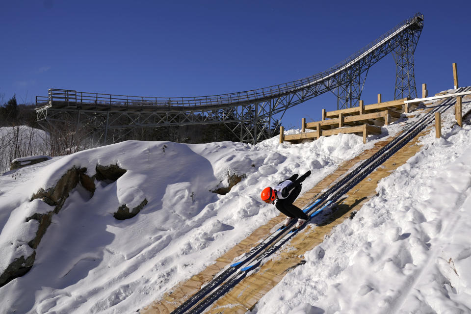 Islay Sheil, 14, of Lakeville, Conn., tucks for speed on the 39-meter jump during the Eastern Ski Jumping Meet in the shadow of "Big Nansen," a 172-foot-tall jump listed on the National Historic Register, Sunday, Jan. 21, 2024, in Milan, N.H. (AP Photo/Robert F. Bukaty)