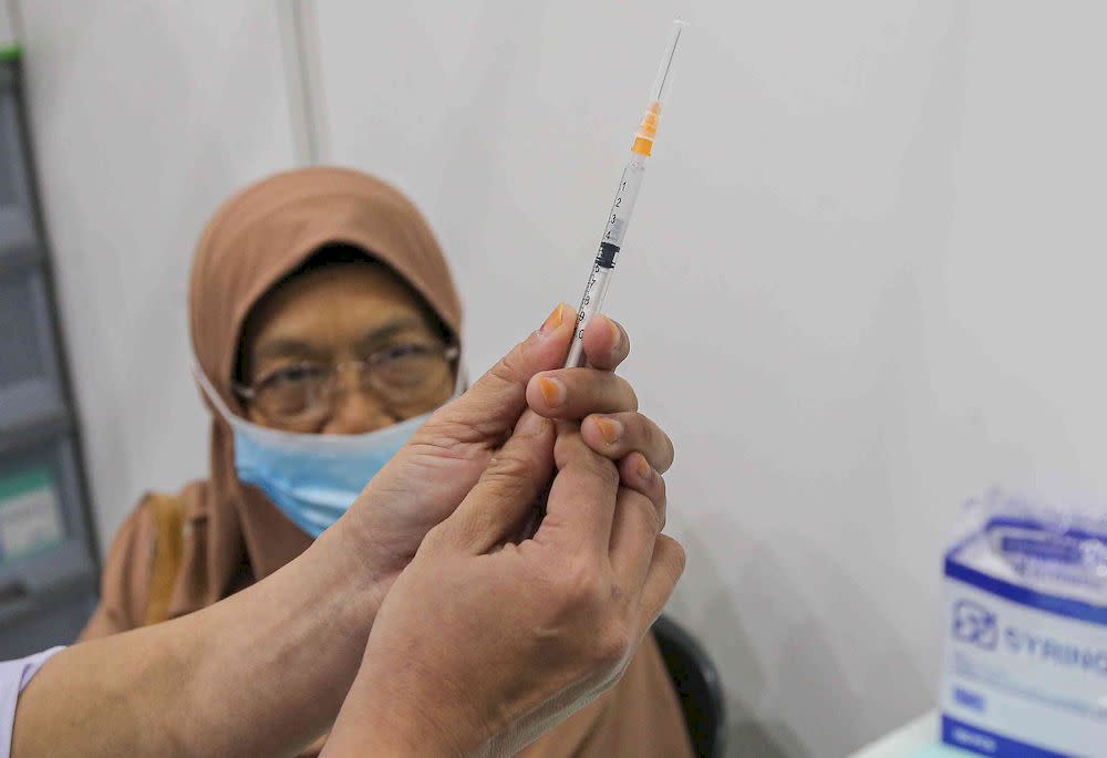 The second phase of vaccination under the National Immunisation Programme going smoothly according to schedule at the vaccination centre (PPV) Stadium Indera Mulia in Ipoh, Perak on June 4, 2021. — Picture by Farhan Najib