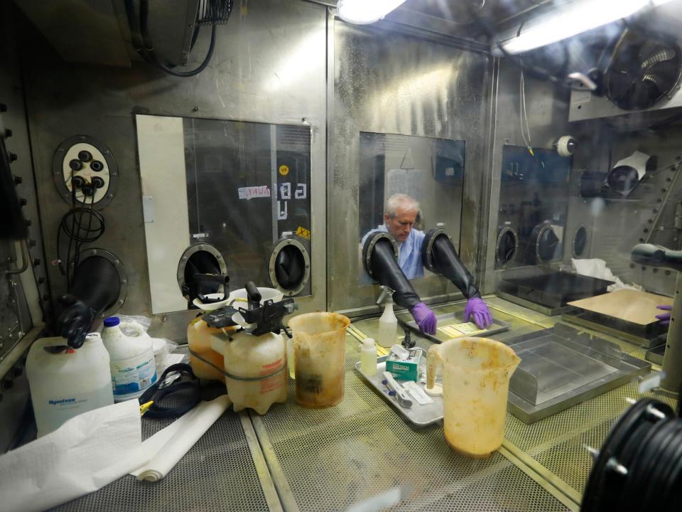 Project chemist Randy Moss works on a project in an airtight chamber at the small item decontamination testing chamber in Dugway Proving Ground in 2017.