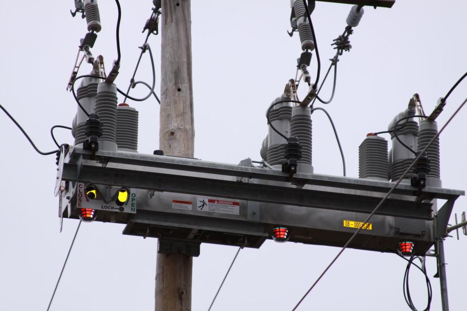 long bar-shaped black device with cylinder on top connected to power lines