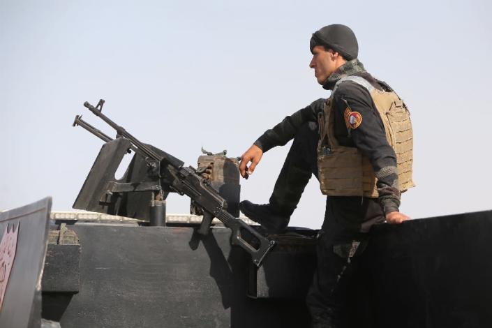 A member of the Iraqi interior ministry's anti-terrorism forces stands guard on a vehicle outside the Habaniyah military base, near Anbar province's capital Ramadi, on May 8, 2015 (AFP Photo/Ahmad Al-Rubaye)