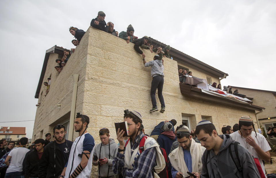 <p>Israeli settlers are gathered on a rooftop of a house as Israeli police evict settlers from the West Bank settlement of Ofra, Tuesday, Feb. 28, 2017. EPA/ATEF SAFADI </p>