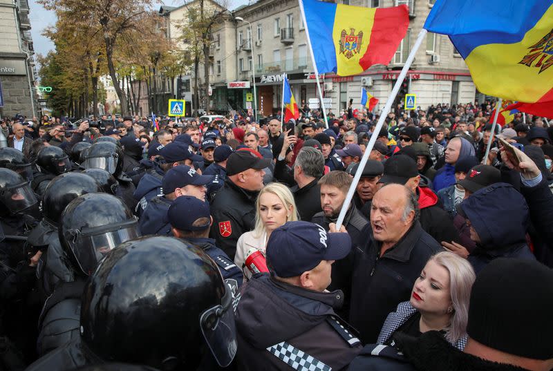 Police officers block a street during an anti-government protest in Chisinau