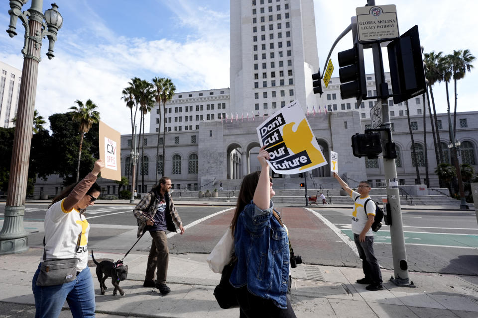 Staff and supporters of the Los Angeles Times carry signs across the street from Los Angeles City Hall during a rally on Friday, Jan. 19, 2024. Guild members of the Los Angeles Times have participated in one-day walkout to protest imminent layoffs. The job action Friday is the first newsroom union work stoppage in the history of the newspaper, which began printing in 1881. (AP Photo/Richard Vogel)