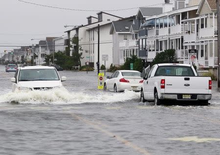 Vehicles drive along a flooded West Avenue as a nor-easter comes on shore in Ocean City, New Jersey, October 2, 2015. Hurricane Joaquin was not expected to be a major threat to the U.S. East Coast, the U.S. National Hurricane Center (NHC) said. REUTERS/Tom Mihalek