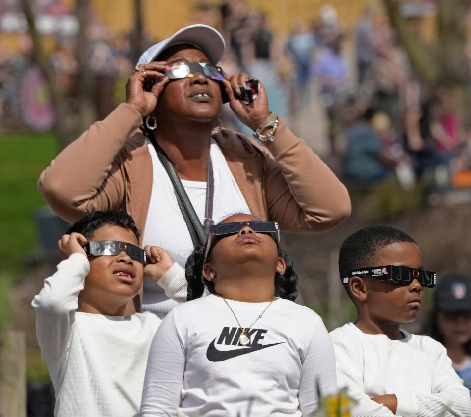 April 8, 2024; Powell, Ohio, USA; 
Thousands of people including Sonya Estis-Bonaman and her grandchildren (l-r) Armond, 7, Giselle, 9, and Armani, 7, watched the total solar eclipse at the Columbus Zoo and Aquarium on Monday afternoon.