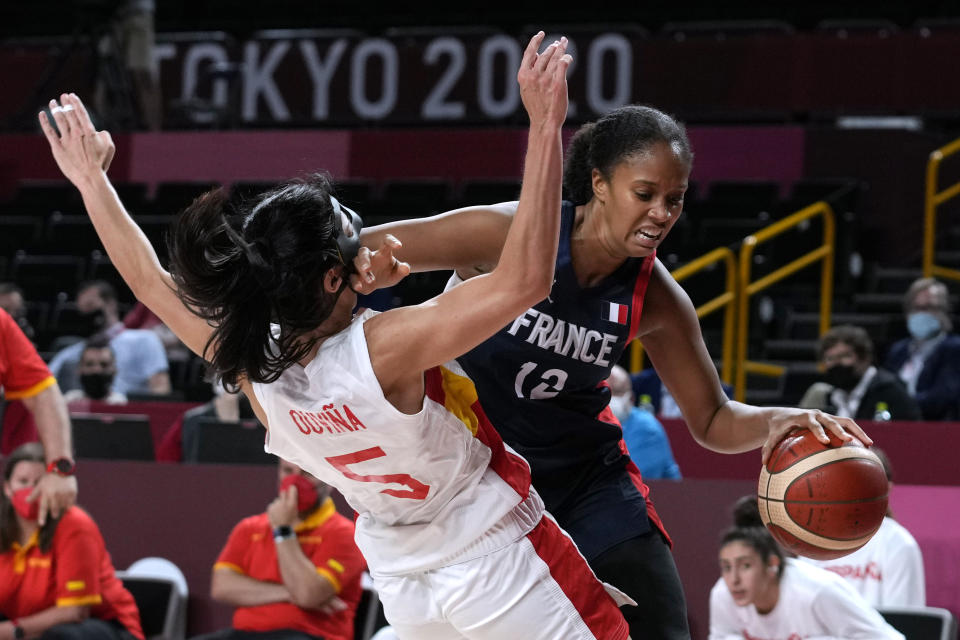 France's Iliana Rupert (12) drives around Spain's Cristina Ouvina (5) during a women's basketball quarterfinal round game at the 2020 Summer Olympics, Wednesday, Aug. 4, 2021, in Saitama, Japan. (AP Photo/Eric Gay)