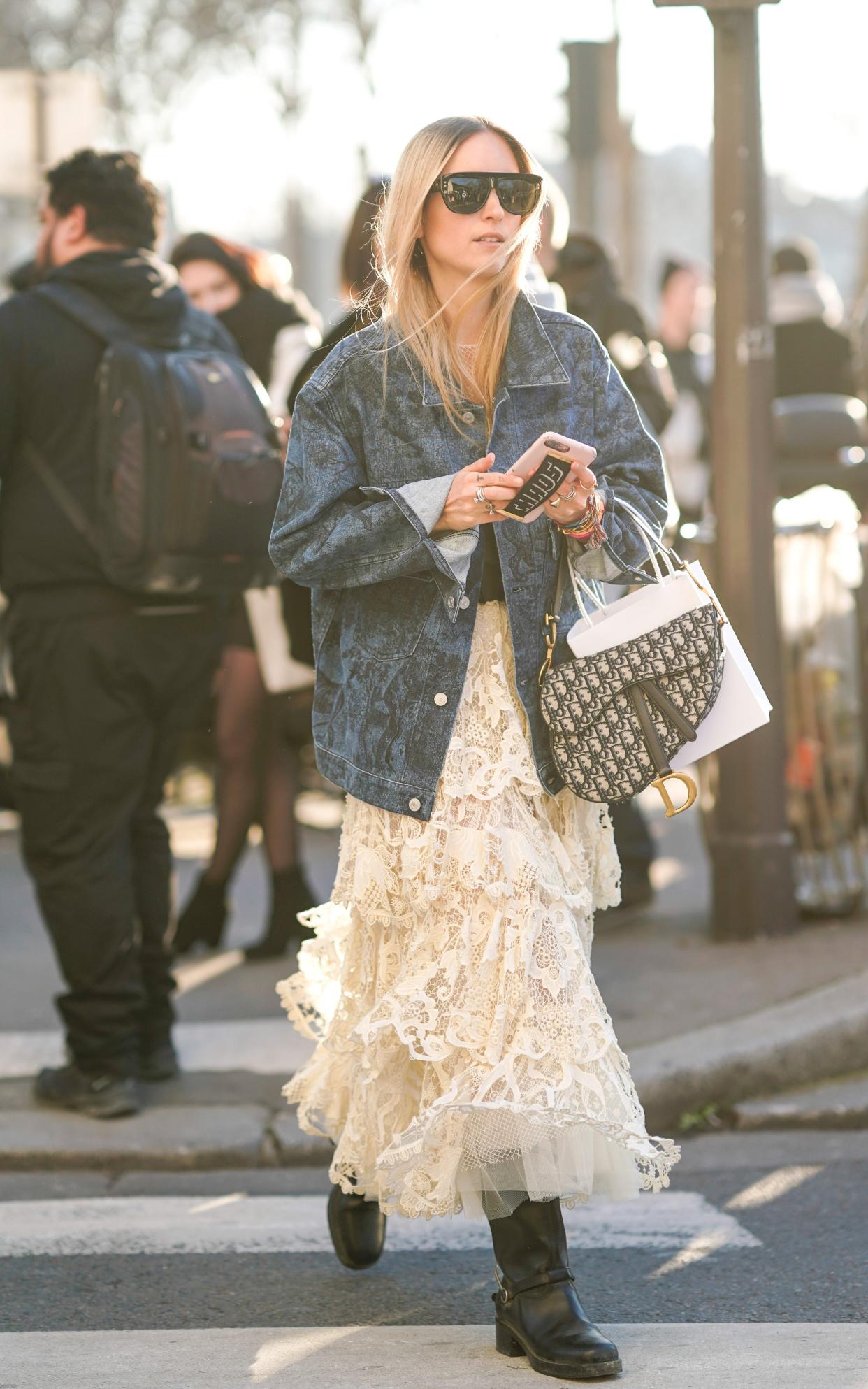 A stylish Paris Fashion Week show-goer paired her tiered lace dress with an oversized denim jacket - perfect bank holiday dressing - 2019 Edward Berthelot