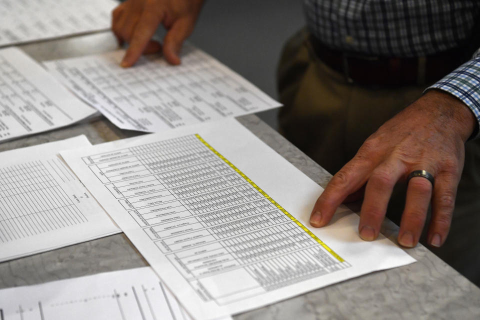 Anderson County Clerk Jason Denny looks over the printouts from the voting machines during the remcanvass of the results from the election for Kentucky Governor in Lawrenceburg, Ky., Thursday, Nov. 14, 2019. Election officials across Kentucky have started double-checking vote totals that show Republican Gov. Matt Bevin trailing Democrat Andy Beshear by more than 5,000 votes. (AP Photo/Timothy D. Easley)