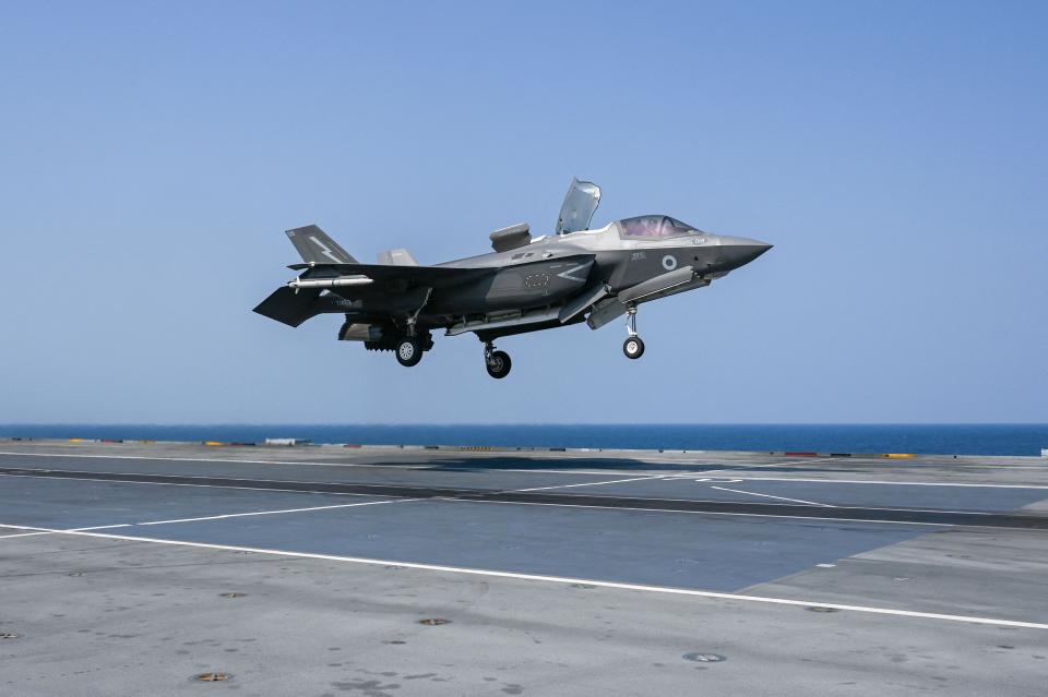 A photo of an F-35 B fighter jet preparing to land on an airship carrier.