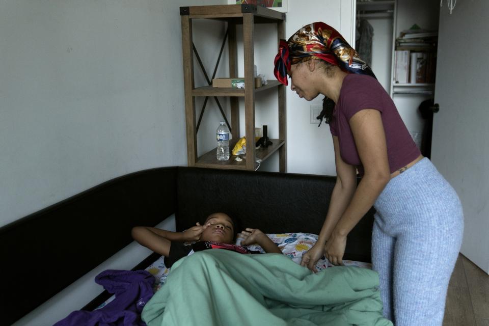 Johnae Strong wakes her 10-year-old son Akeim Smith as they ready for school and work Friday, Feb. 10, 2023, in Chicago. (AP Photo/Erin Hooley)