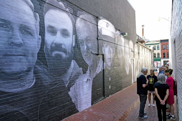 PHOTO: People visit a mural depicting photos of American hostages around the world, created by the Bring Our Families Home Campaign, is seen in the Georgetown neighborhood of Washington, D.C., July 20, 2022. (Sarah Silbiger/Reuters)