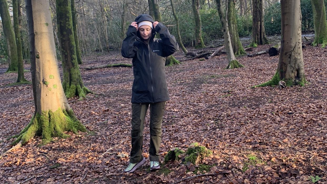  Julia Clarke wearing the Montane Solution Jacket in the forest. 