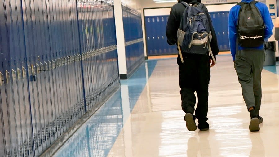 High school students walk down a hallway. (AP Photo/Matt York)