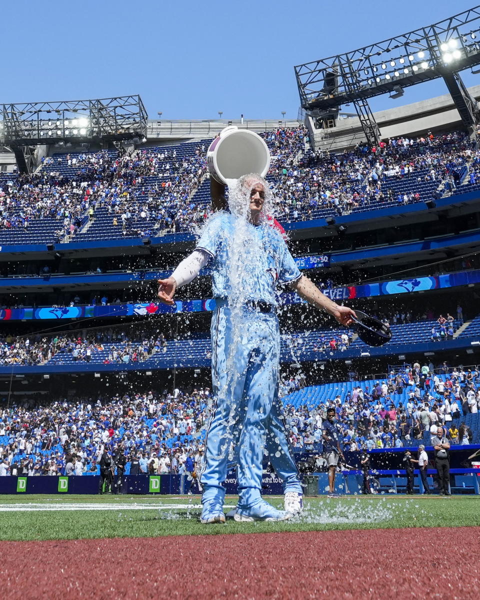 Toronto Blue Jays third baseman Matt Chapman (26) gets doused by teammate Vladimir Guerrero Jr. after defeating the Milwaukee Brewers in a baseball game, Thursday, June 1, 2023, in Toronto. (Andrew Lahodynskyj/The Canadian Press via AP)