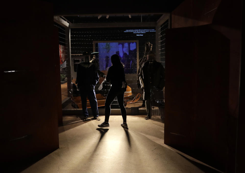 In this picture taken on Tuesday, Nov. 12, 2019, a visitor views the exhibition "The Technology in Dictatorships," at the National technical Museum in Prague, Czech Republic. The exhibition, the first of that kind here, marks the 30th anniversary of the 1989 anti-communist Velvet Revolution by looking back at the surreal repression of a nation and resistance against it. (AP Photo/Petr David Josek)