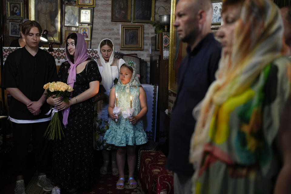 Relatives of Pavlo Savryha and Oksana Savryha attend their wedding in Chernihiv, Ukraine, Sunday, June 19, 2022. The couple decided to marry after 18 years of being registered as a family, the day before Pavlo went to the frontline. A growing number of couples in Ukraine are speedily turning love into matrimony because of the war with Russia. Some are soldiers, marrying just before they head off to fight. Others are united in determination that living and loving to the full are more important than ever in the face of death and destruction. (AP Photo/Natacha Pisarenko)