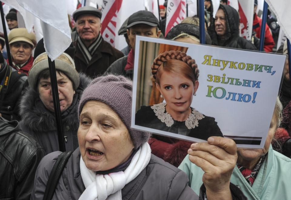 A supporter of jailed former Ukrainian Prime Minister and opposition leader Tymoshenko holds a portrait of her during a rally in front of the Parliament building in Kiev