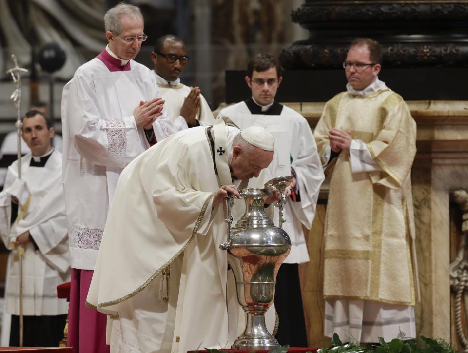 Pope Francis blows inside an amphora containing holy oil during a Chrism Mass inside St. Peter's Basilica, at the Vatican, Thursday, April 18, 2019. During the Mass the Pontiff blesses a token amount of oil that will be used to administer the sacraments for the year. (AP Photo/Alessandra Tarantino)