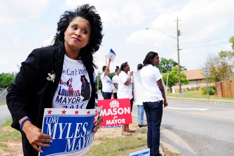 Lori Myles holds a campaign sign during her first bid for mayor of Augusta in 2014. Myles in November filed a declaration of intent to run again for mayor in the May 2022 election.