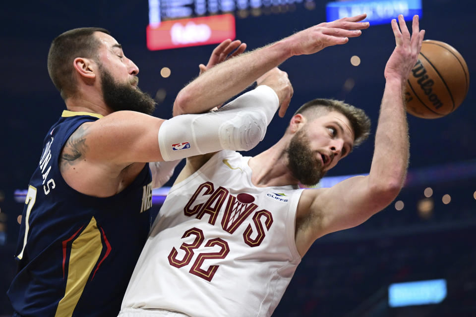 New Orleans Pelicans center Jonas Valanciunas and Cleveland Cavaliers forward Dean Wade vie for a rebound during the first half of an NBA basketball game, Thursday, Dec. 21, 2023, in Cleveland. (AP Photo/David Dermer)